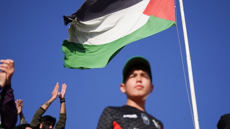 Club Palestino soccer team fans watch their team's game with...