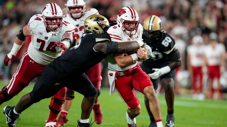 Wisconsin quarterback Tanner Mordecai (8) is tackled by then-Purdue linebacker...