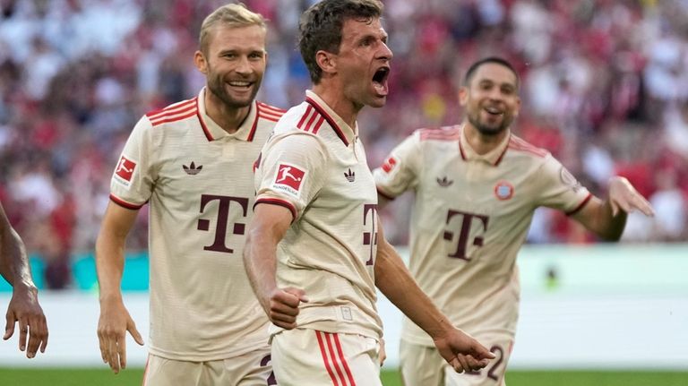 Bayern's Thomas Mueller, center, celebrates after scoring his side's second...