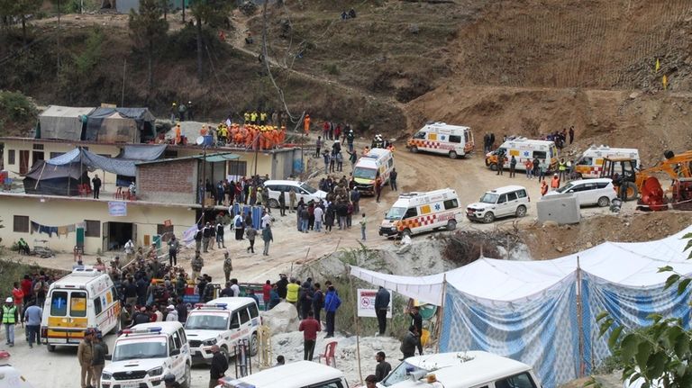 Ambulances wait to carry workers from the site of an...