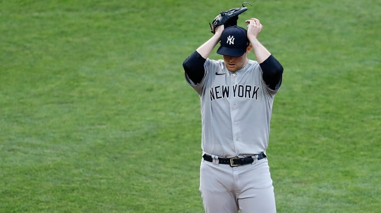 Yankees starting pitcher Jordan Montgomery adjusts his cap after walking...