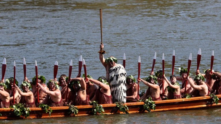 A waka, a traditional canoe, is paddled by warriors as...