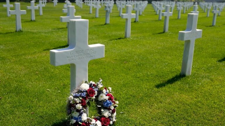 A wreath is placed in front of the grave of...