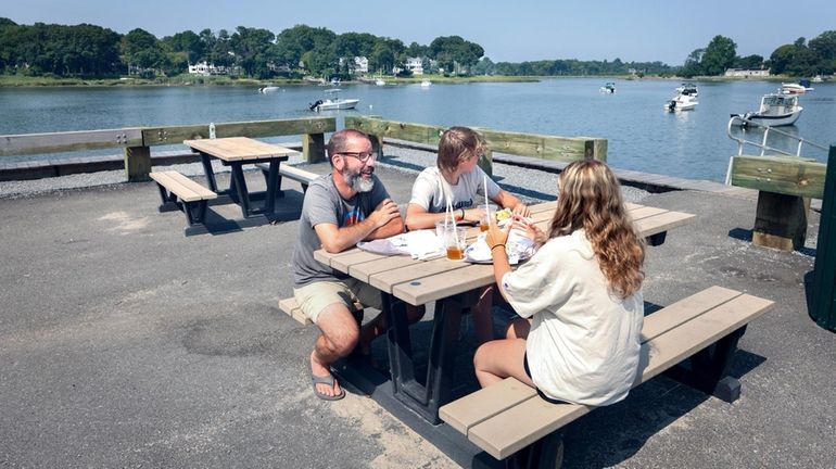 With a view of Setauket Harbor, Kevin Stiegelmaier, left, his...