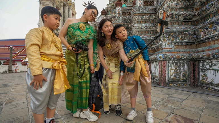 Chinese family tourists rent traditional Thai costumes and take selfies...