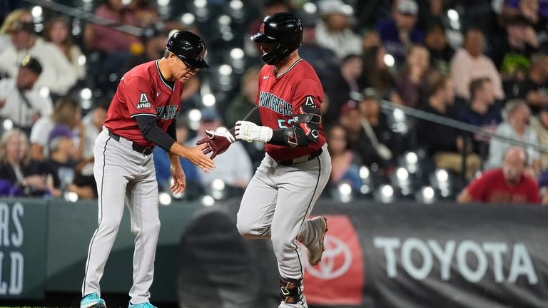 Arizona Diamondbacks third base coach Tony Perezchica, left, congratulates Christian...