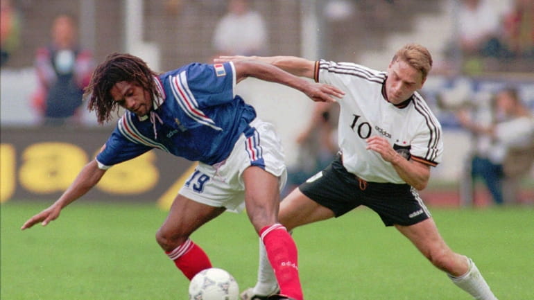 Christian Karembeu of France, left, protects the ball during the...
