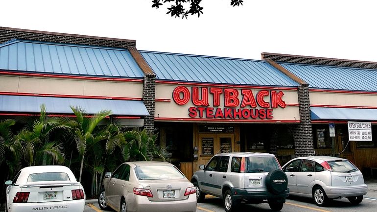 Vehicles are parked outside of an Outback Steakhouse restaurant, June...