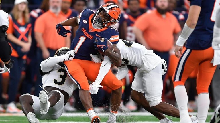 Syracuse running back LeQuint Allen Jr., center, is tackled by...