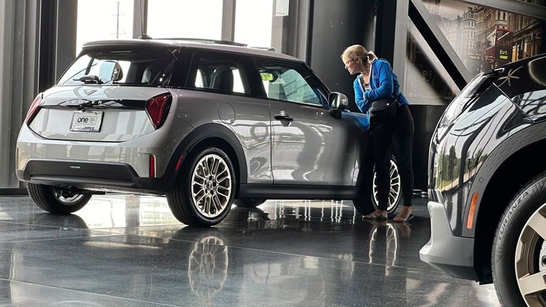 A prospective buyer examines a 2025 Cooper S hardtop on...