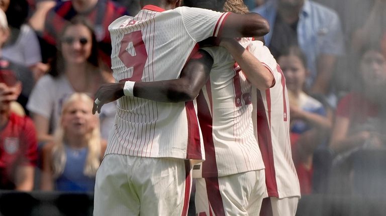 Canadian players celebrate after a goal during the first half...