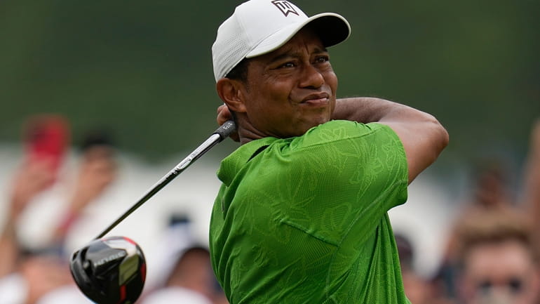 FILE - Tiger Woods watches his tee shot on the...