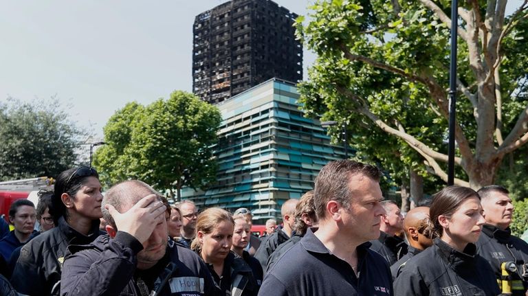 Emergency services workers take part in a minute's silence in...