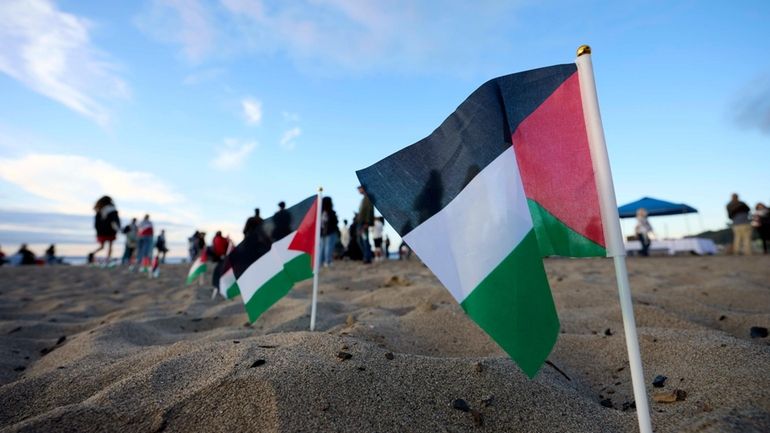 Palestinian flags are seen during a vigil on Alki Beach...