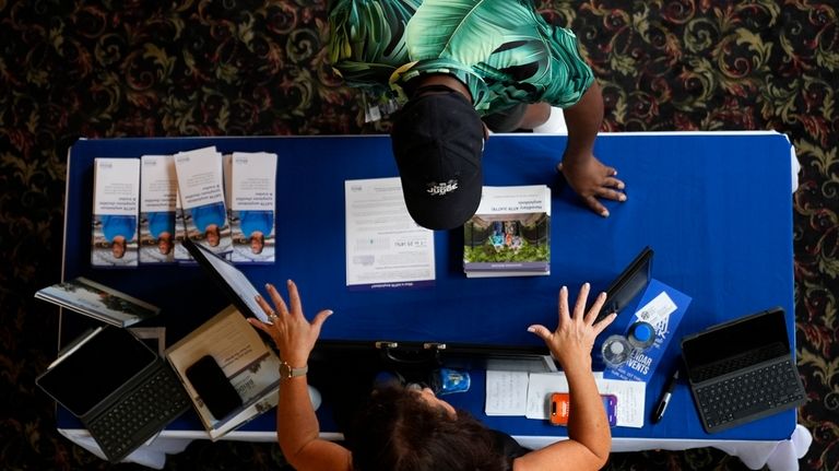 A woman talks to an attendee at the Black Health...