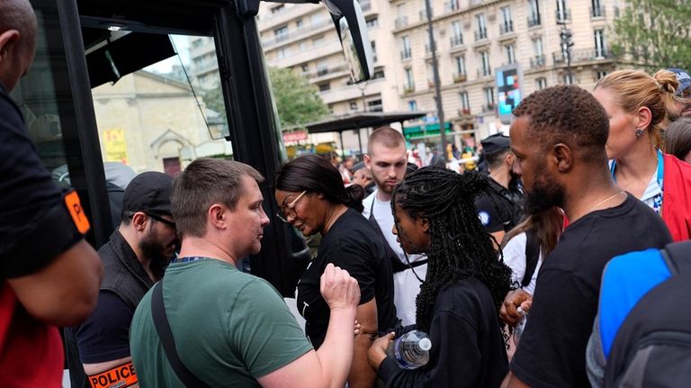 Migrants board a bus after a demonstration at the 2024...