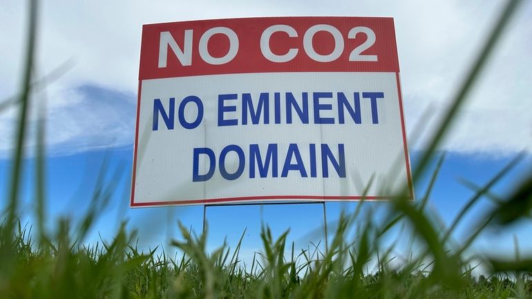 A sign reading "No CO2, no eminent domain" stands along...