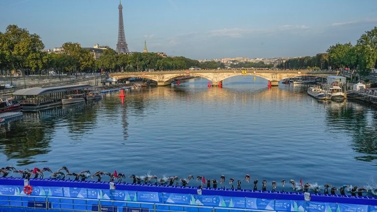 Athletes dive into the Seine River from the Alexander III...