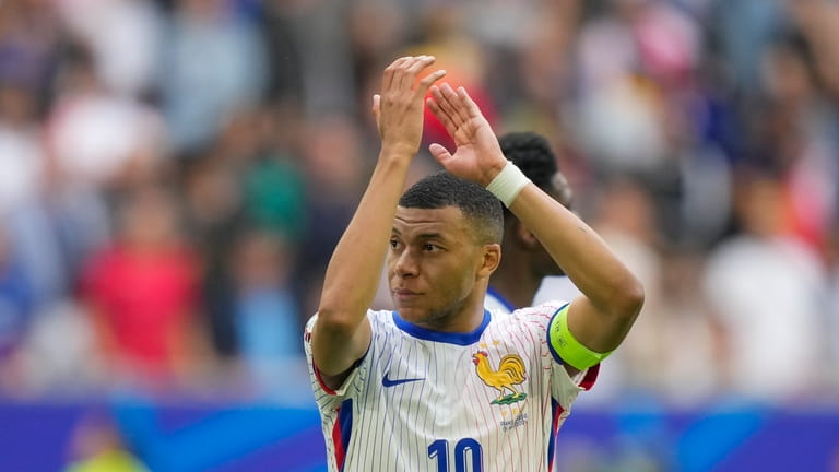 Kylian Mbappe of France applauds to fans after a round...