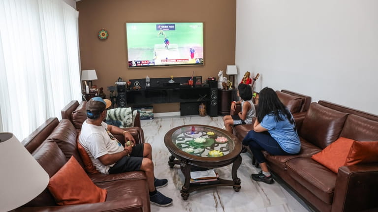 The Raghunath family watches cricket at home in Deer Park...
