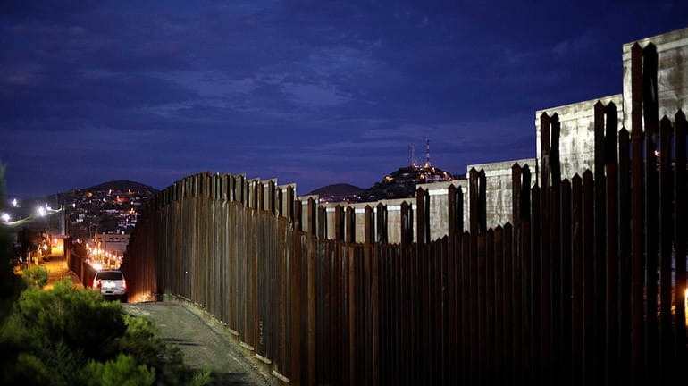 The border wall is illuminated at night in Nogales, Arizona....