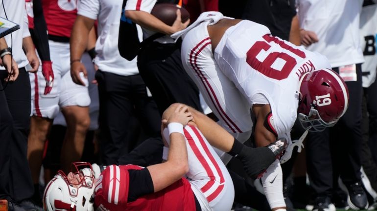 Wisconsin's Tyler Van Dyke (10) holds his knee after bein...