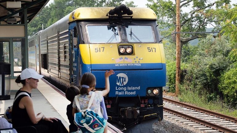 Riders greet a train at the Oyster Bay station in...