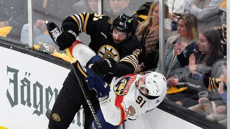 Boston Bruins' Pat Maroon (61) checks Florida Panthers' Oliver Ekman-Larsson...