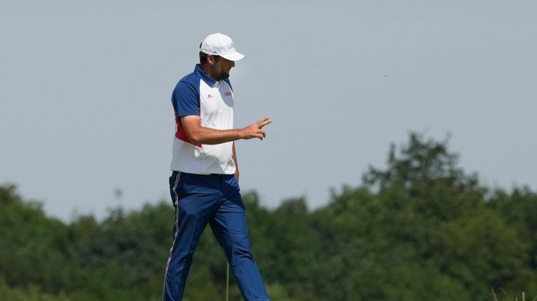 Scottie Scheffler, of the United States, reacts to the crowd...