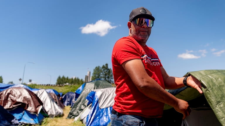Jose Guerrero, of Puerto Cabello, Venezuela, stands near his tent...