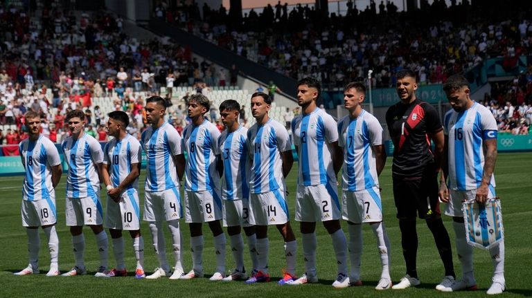 Argentina's starting players listen the national anthems prior to the...