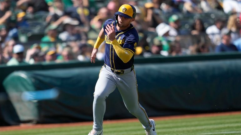 Milwaukee Brewers' Jake Bauers runs home to score against the...