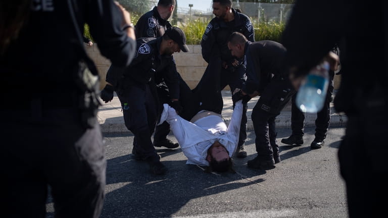 Israeli police officers remove an ultra-Orthodox Jewish man from the...