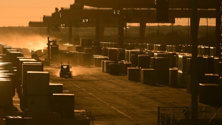 Trucks drive amongst shipping containers at a BNSF intermodal terminal...