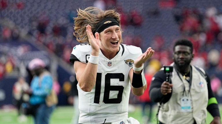 Jacksonville Jaguars quarterback Trevor Lawrence (16) celebrates as he jogs...