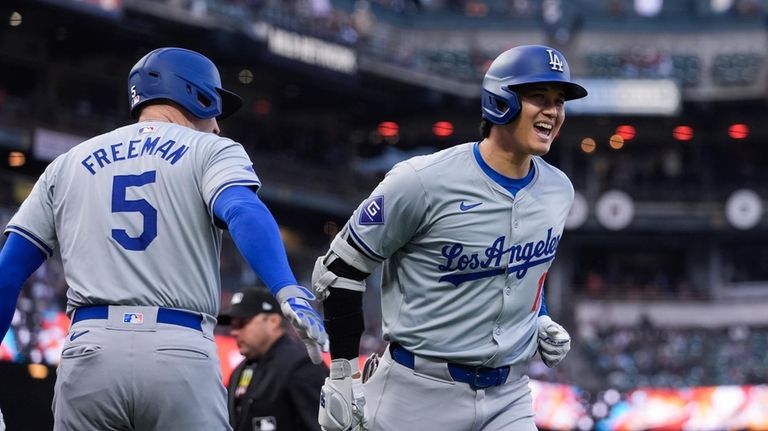 Los Angeles Dodgers' Shohei Ohtani, right, is congratulated by Freddie...