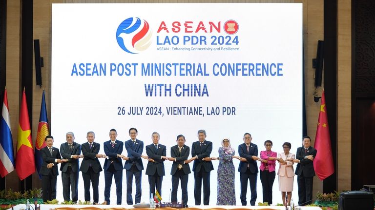 Chinese Foreign Minister Wang Yi, 6th from left, poses for...