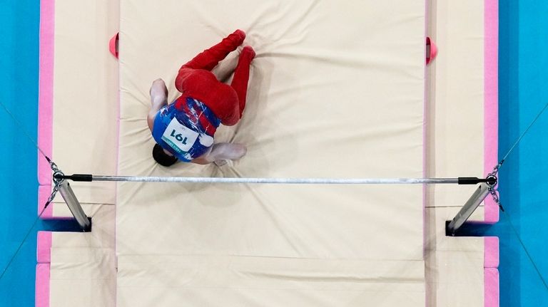 Brody Malone, of United States, falls from the bar during...