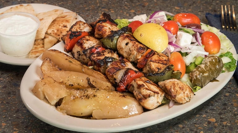 Chicken kebab platter with lemon roasted potatoes and Greek salad,...