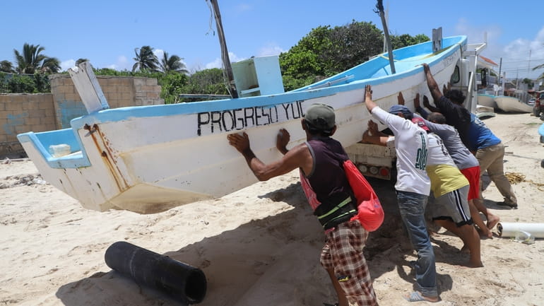 People relocate a boat for its protection ahead of the...