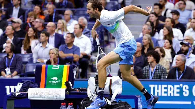 Daniil Medvedev, of Russia, leaps over the player's bench on...