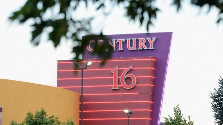 People stand in the parking lot outside the Century 16...