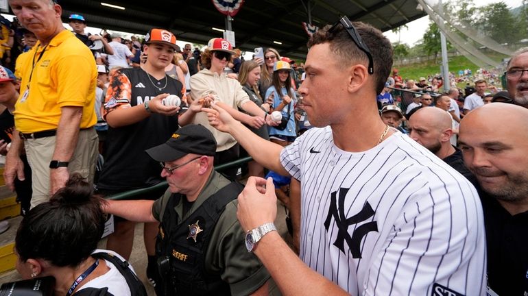 The Yankees' Aaron Judge, right, makes his way to his...