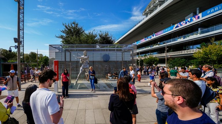 People gather next to the statue of Spanish artist Jordi...