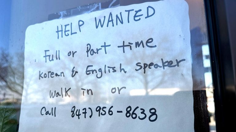 A hiring sign is displayed at a restaurant in Mount...