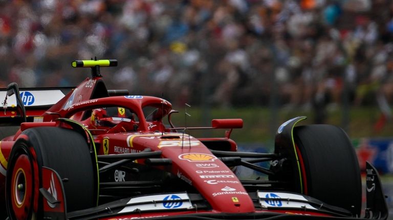 Ferrari driver Carlos Sainz of Spain steers his car during...