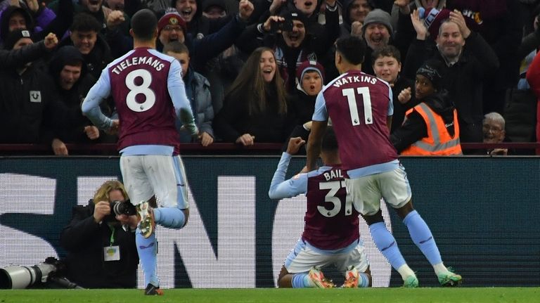 Aston Villa's Leon Bailey, bottom, celebrates with teammates after scoring...