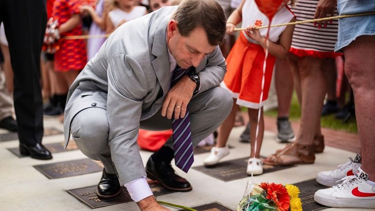 Clemson head coach Dabo Swinney stops to pay his respects...