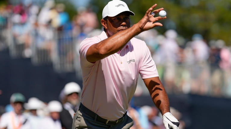 Tiger Woods catch a ball on the ninth hole during...