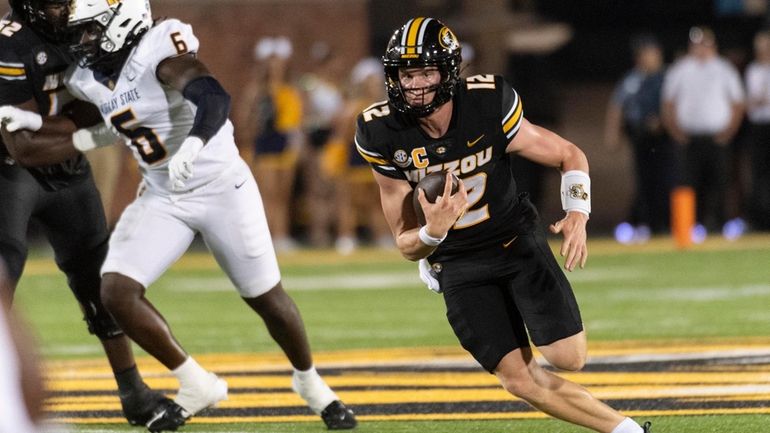 Missouri quarterback Brady Cook, right, runs past Murray State defensive...